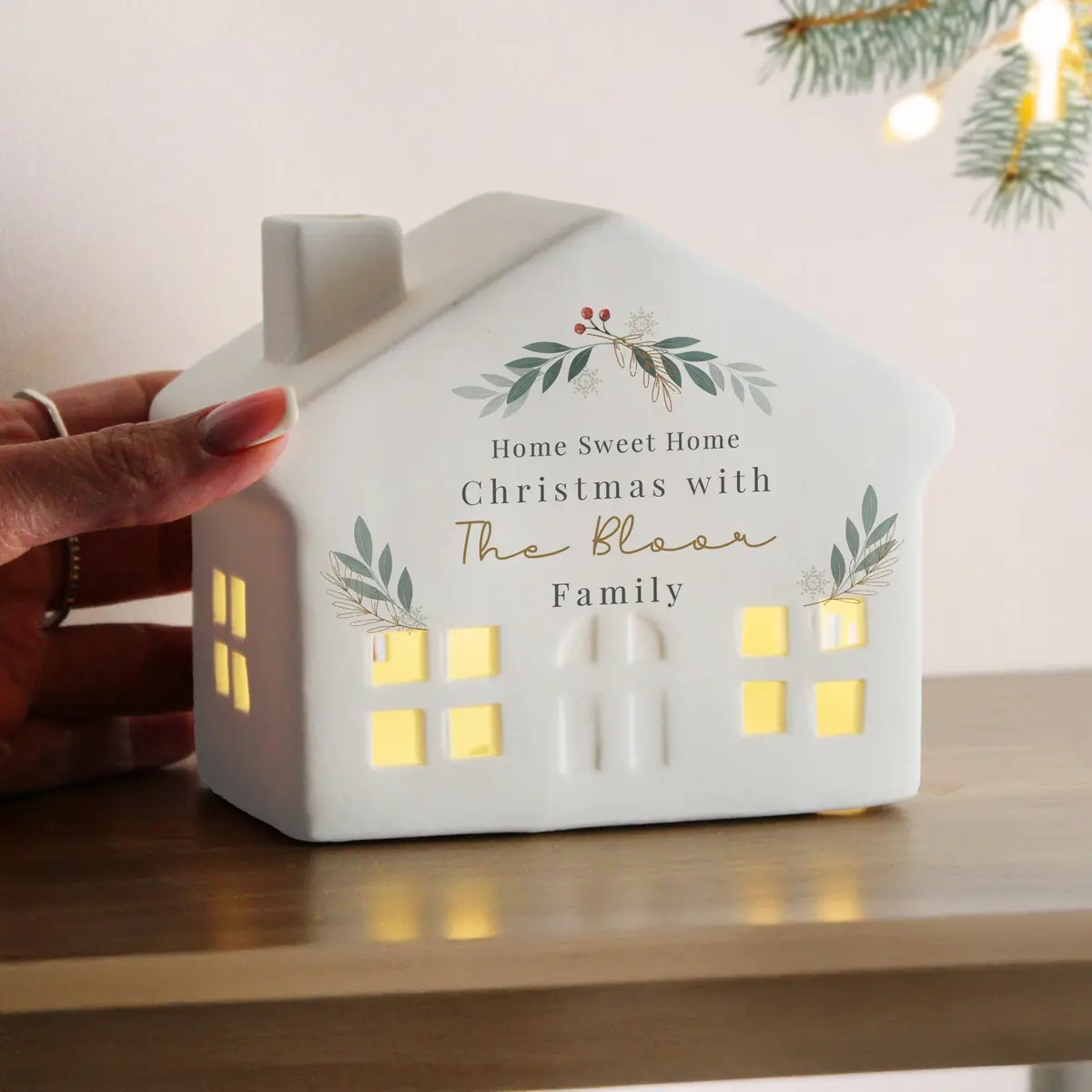 Ceramic Christmas house with cut-out windows lit by LED and personalised message lines